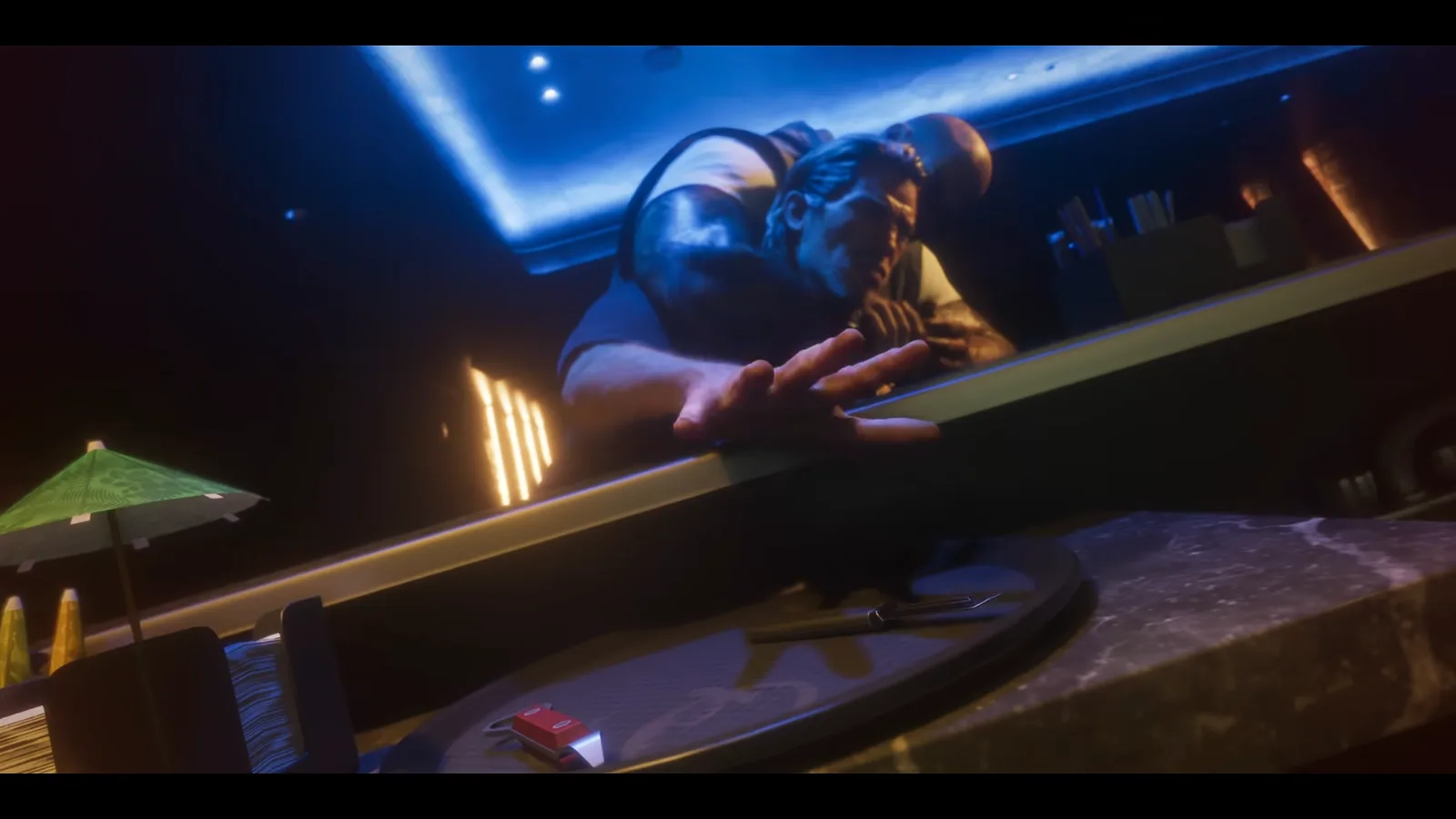GTA 6 Launch Trailer: a man reaches across a bar counter toward a round tray holding a small blade and a red lighter under blue light