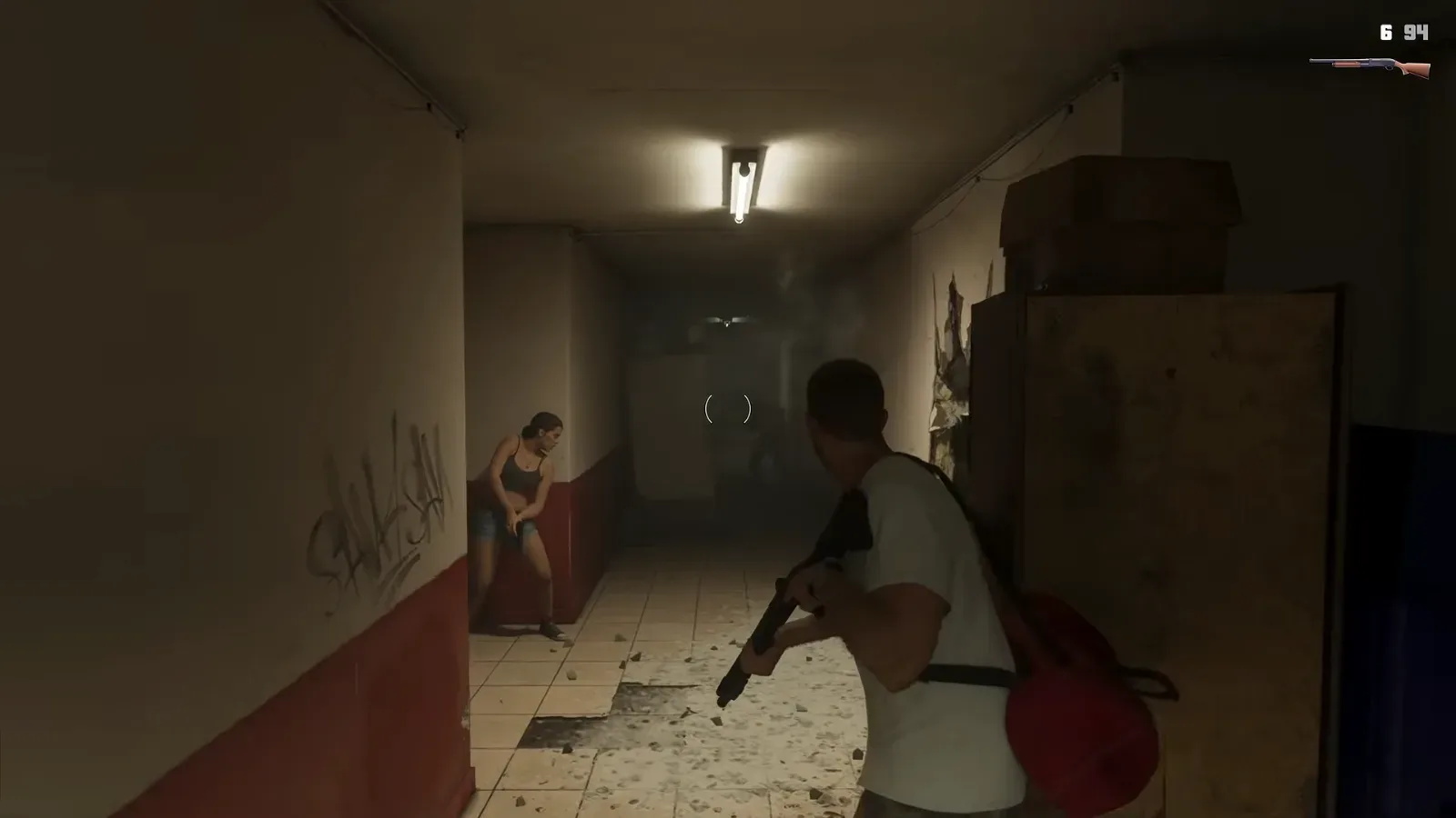 GTA 6 Extended Look: Jason holds a shotgun in both hands at the end of a motel corridor while Lucia crouches against the wall ahead