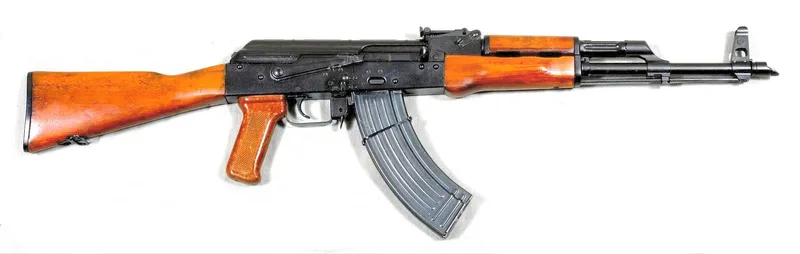 A real AKM 7.62x39mm assault rifle with wooden furniture, left side view, museum photo on a white background