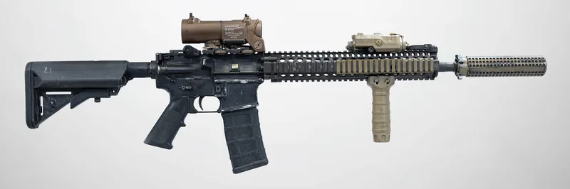 A real M4A1 SOPMOD Block II carbine with a suppressor, optic and foregrip, left side view, on a light grey background
