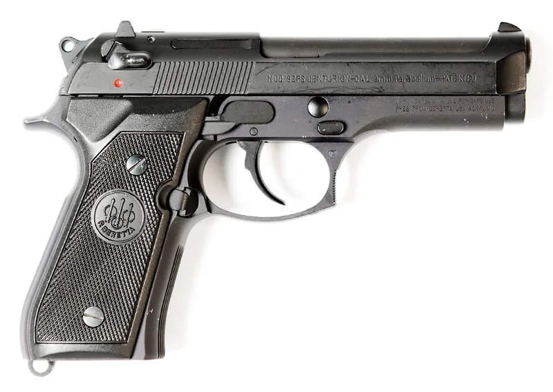 A real Beretta 92FS 9mm pistol, left side view with the slide forward, on a plain white background