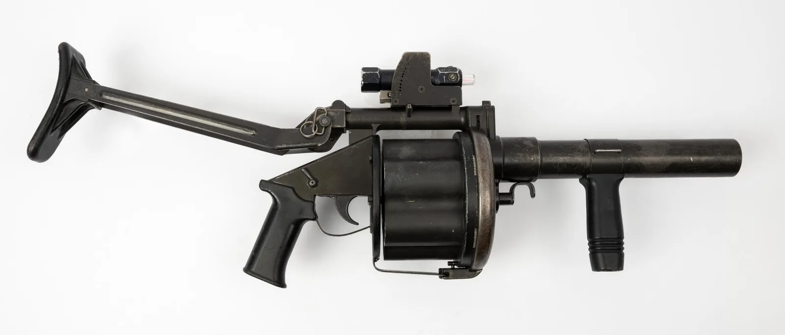 A real Milkor MGL 40mm six-shot grenade launcher made by Armscor, side view with the stock unfolded, museum photo on white
