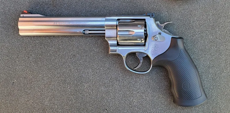 A real stainless Smith & Wesson Model 629 Classic .44 Magnum revolver with a 6.5-inch barrel, side view, on grey stone