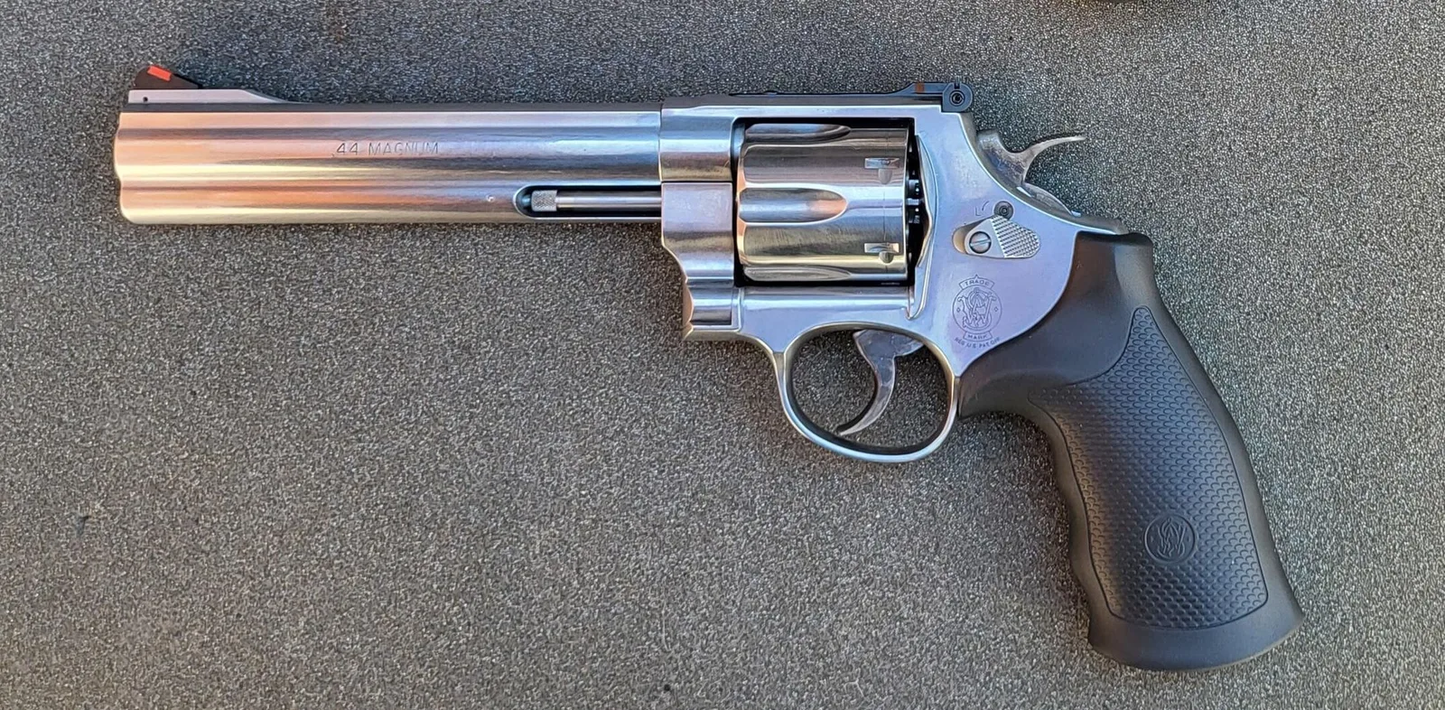 A real stainless Smith & Wesson Model 629 Classic .44 Magnum revolver with a 6.5-inch barrel, side view, on grey stone